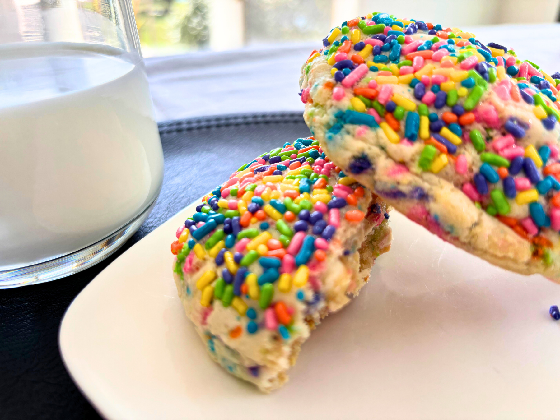 The Circus cookie, a colorful cake batter and sugar cookie hybrid topped with funfetti sprinkles, frosted animal crackers, and white chocolate drizzle.