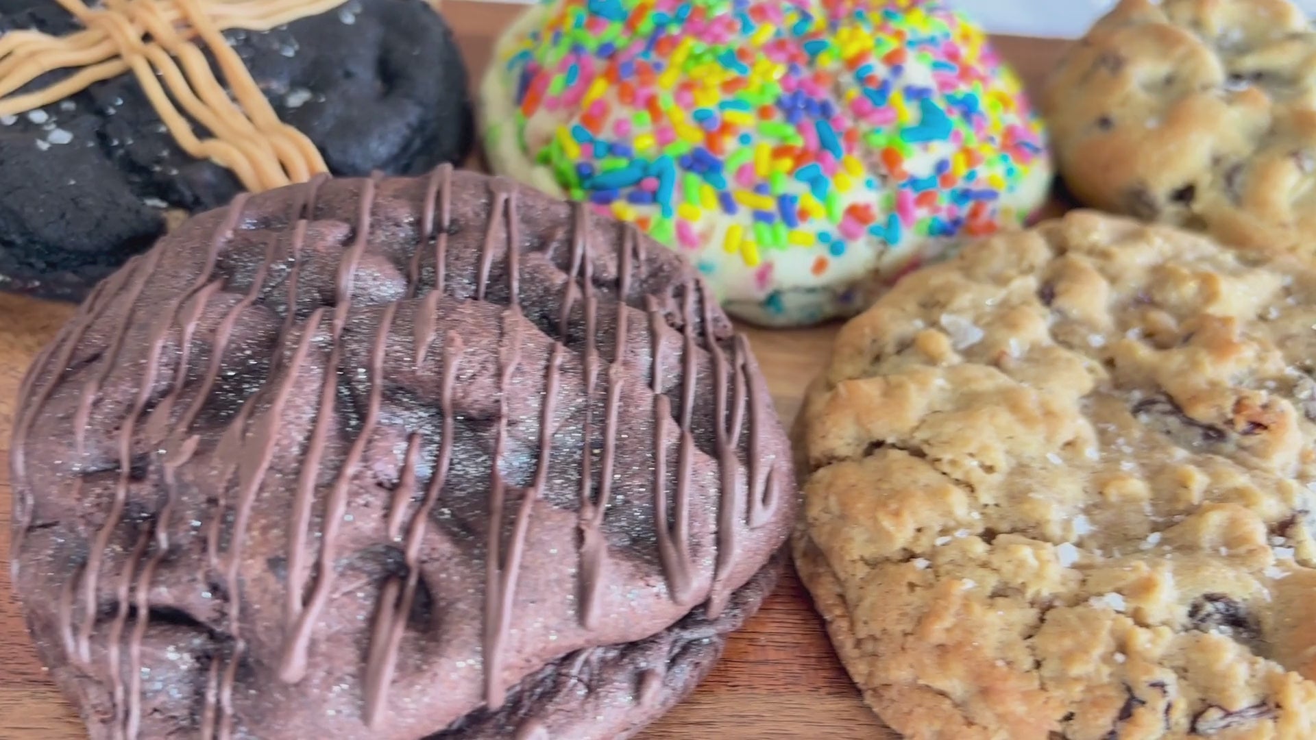 Horizontal scrolling video showcasing all six thick, best-selling cookies, including chocolate chip, funfetti, oatmeal raisin, and peanut butter varieties.
